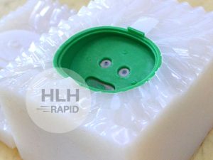 Vacuum cast part with green dye surface finish